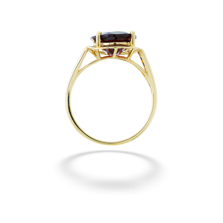 Gold ring with a brown gemstone on a white background Oval Garnet Ring