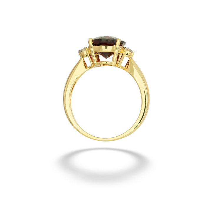 A yellow gold ring featuring a marquise-cut dark brown gemstone in a four-prong setting, shown against a clean white background with a soft shadow below. Oval Garnet and Diamond Ring 