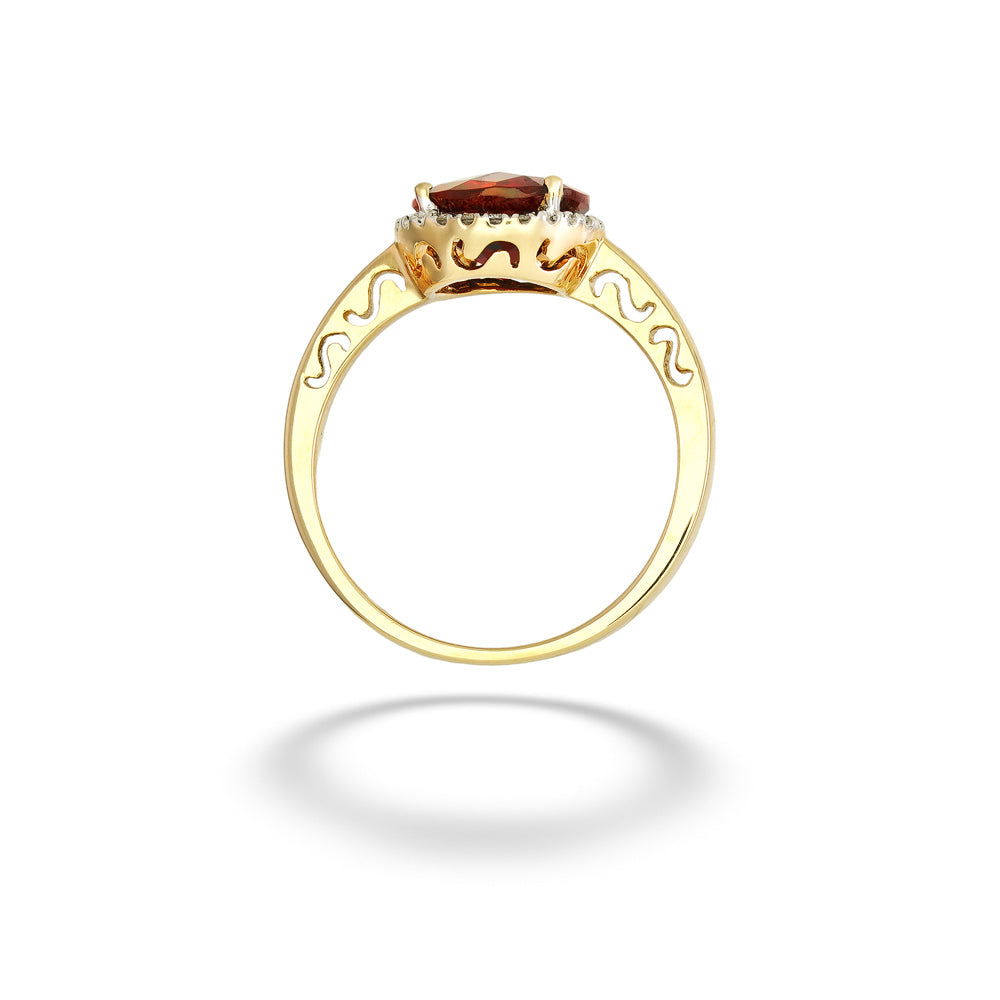 A gold ring with a central oval brown gemstone, surrounded by small clear stones and decorative scrollwork on the band, shown on a white background with a soft shadow. Garnet with Diamond Halo Ring