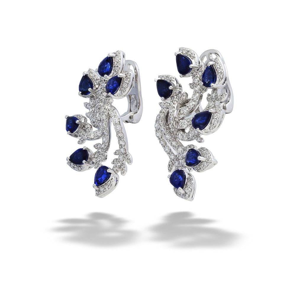 Pair of silver earrings with blue gemstones on a white background Sapphire and Diamond “Feather” Earrings