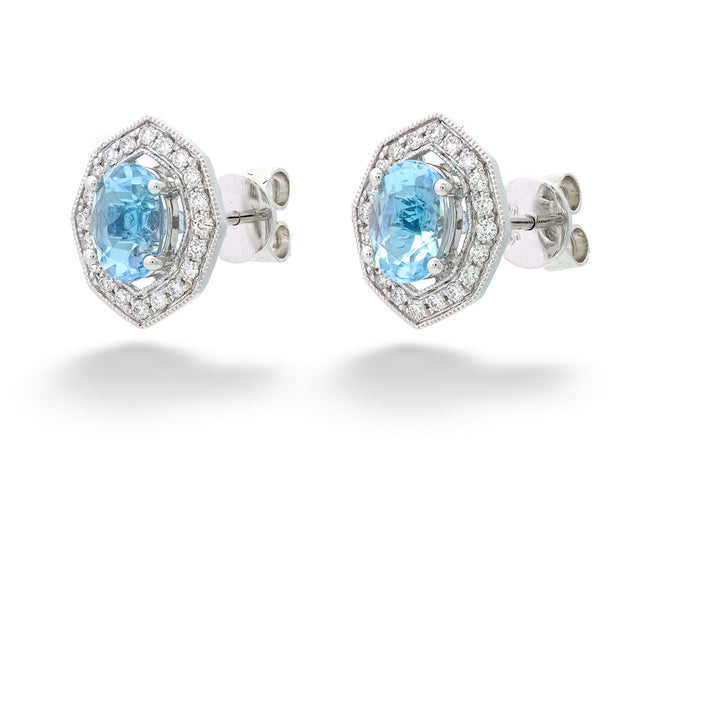 Pair of earrings with blue gemstones and silver accents on a white background Aquamarine and Diamond Halo Earrings 