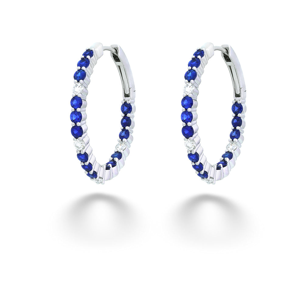 Pair of hoop earrings with blue and clear gemstones on a white background Sapphire and Diamond Inside/Out Hoops