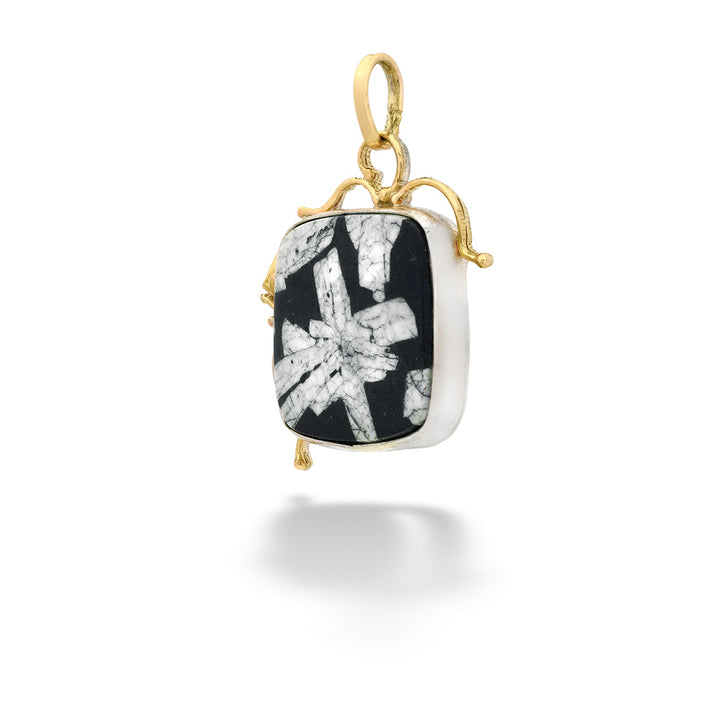 Jewelry pendant with black and white pattern on a gold chain against a white background Chinese Writing Stone Pendant by The Village Smithe 