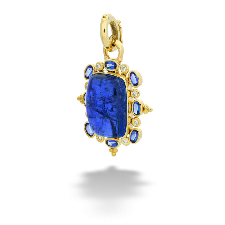 Gold pendant with a blue gemstone on a white background Cabachon Tanzanite Pendant with Diamond and Tanzanite Halo by Mazza