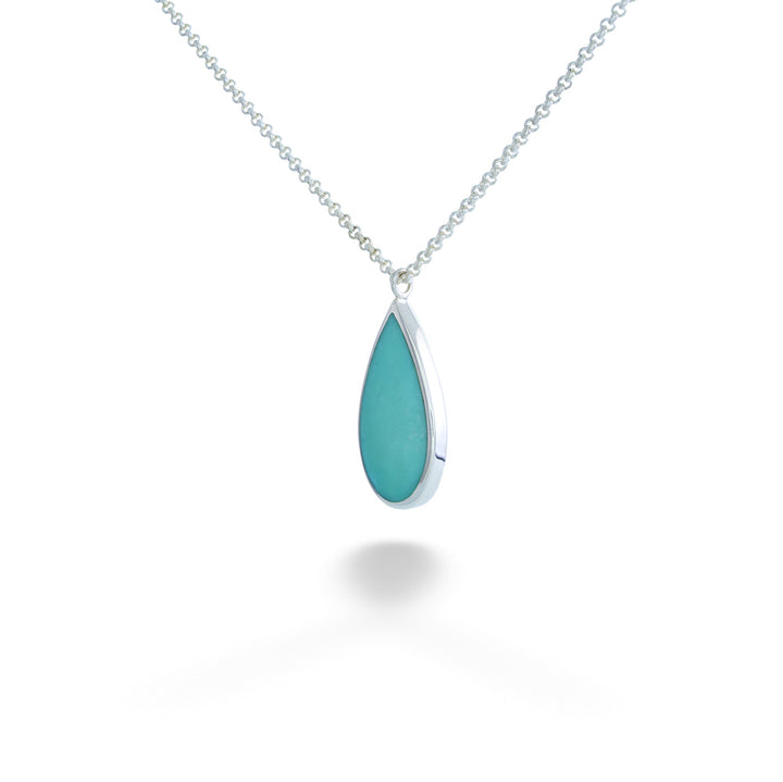 Teardrop-shaped turquoise pendant on a silver chain against a white Turquoise Drop Pendant Necklace by Acleoni background