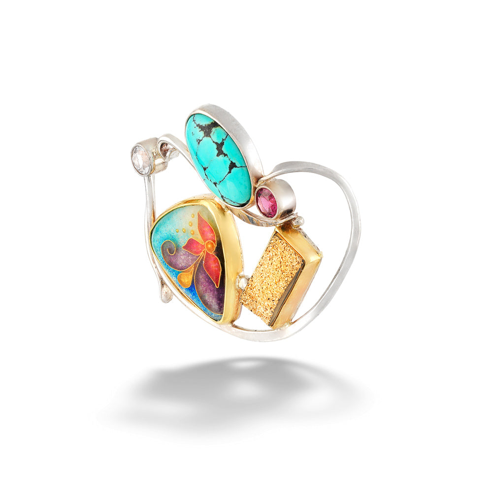 A gold and silver heart-shaped ring featuring a turquoise stone, a colorful butterfly enamel motif, a textured gold block, and a small pink gemstone, shown on a white background with a soft shadow.Graceful Balance Enamel Enhancer by Katrin Wolf
