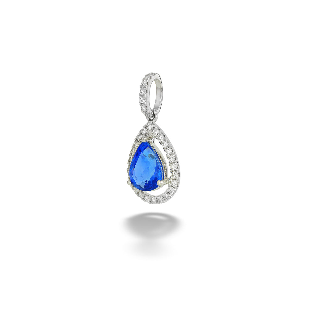 A teardrop-shaped pendant featuring a vibrant blue gemstone surrounded by a halo of small clear stones in a silver-toned setting, shown on a clean white background with a soft shadow below. Pear-Shape Blue Sapphire and Diamond Pendant