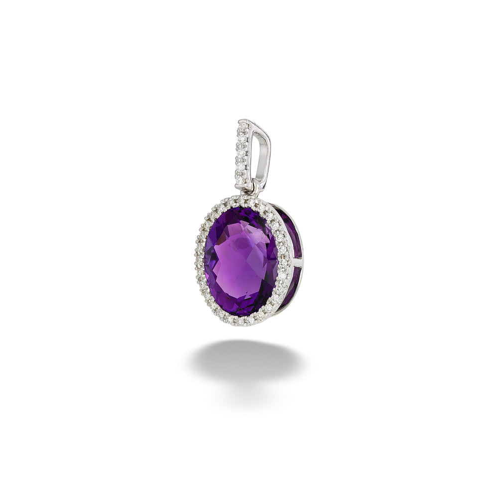 An oval purple amethyst pendant in a silver-toned setting, surrounded by a halo of small clear stones, shown on a white background with a soft shadow below. Oval Amethyst with Diamond Halo Pendant