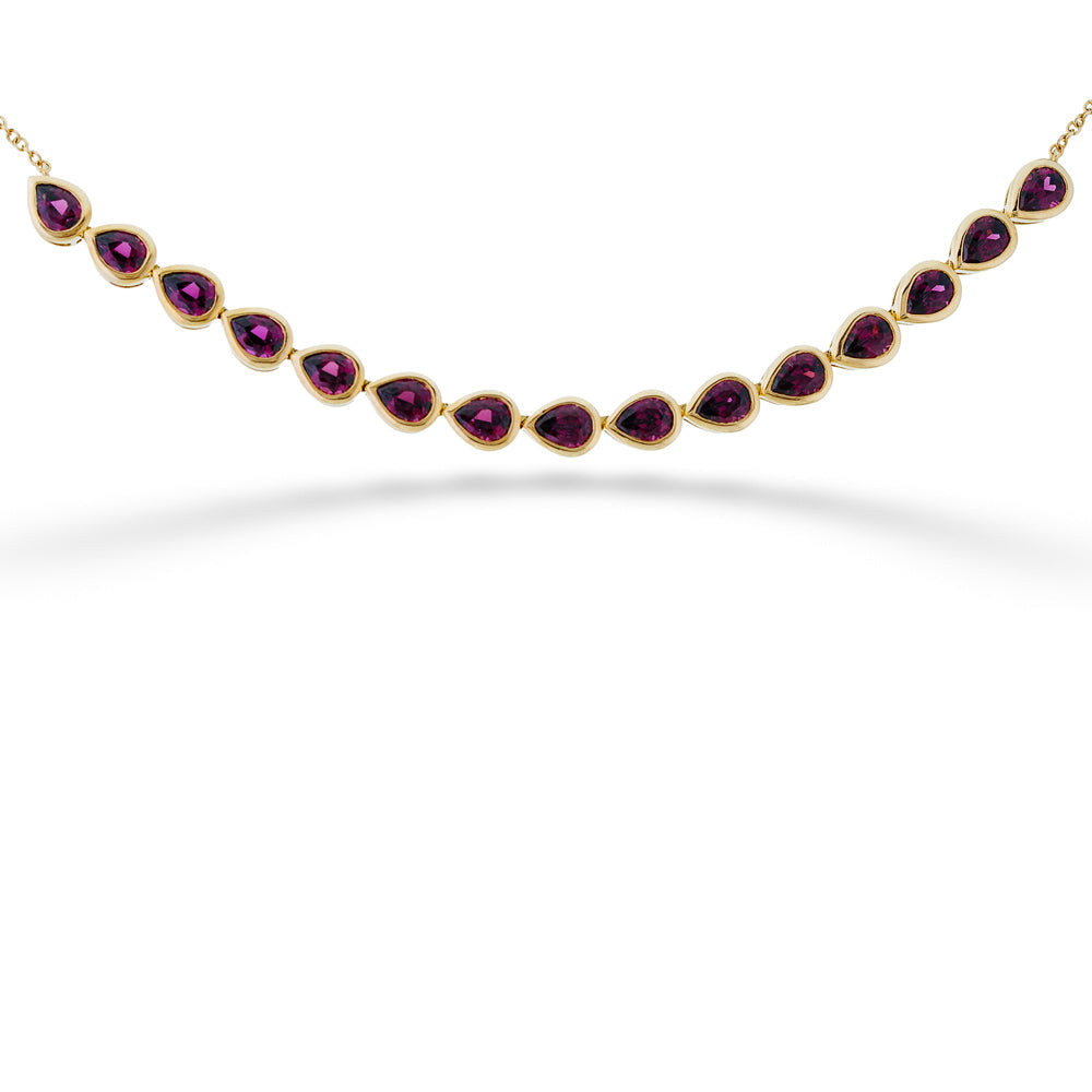 Gold necklace with purple gemstones on a white background Pear Shape Garnet Bar Necklace