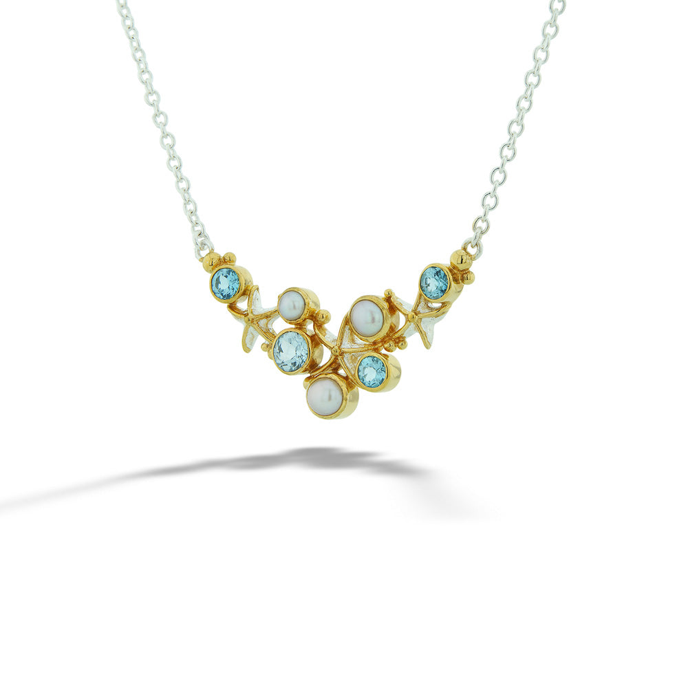Gold necklace with gemstones on a white background Blue Topaz and Pearl Starfish Necklace by Michou