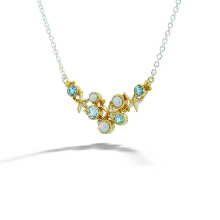 Gold necklace with gemstones on a white background Blue Topaz and Pearl Starfish Necklace by Michou