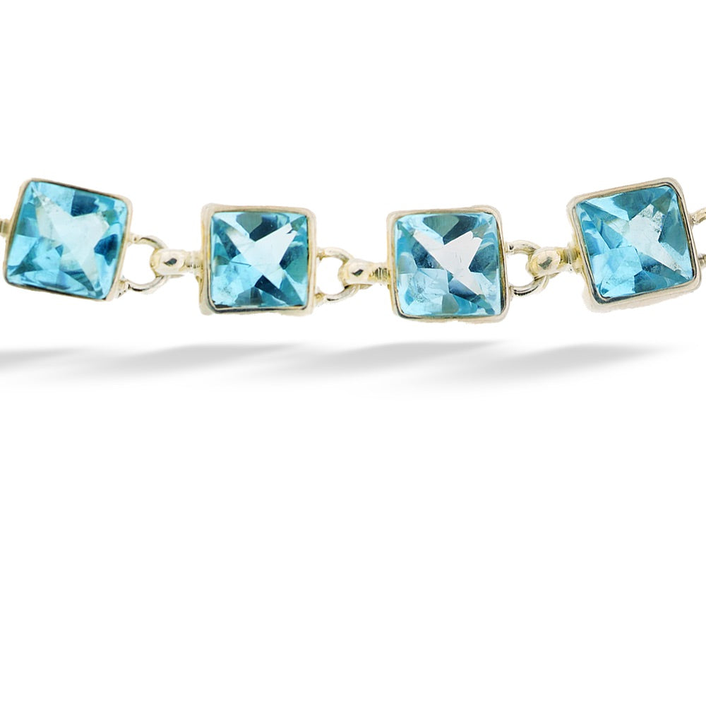 Gold bracelet with blue gemstones on a white background  Square Blue Topaz Bracelet by Acleoni 