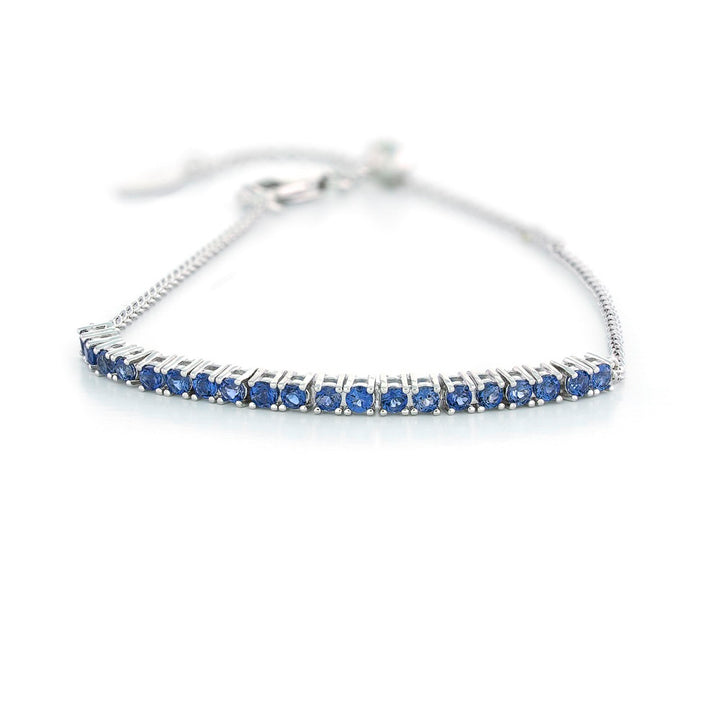 Silver bracelet with blue stones on a white background Adjustable London Blue Topaz Bar Bracelet by Samuel B.