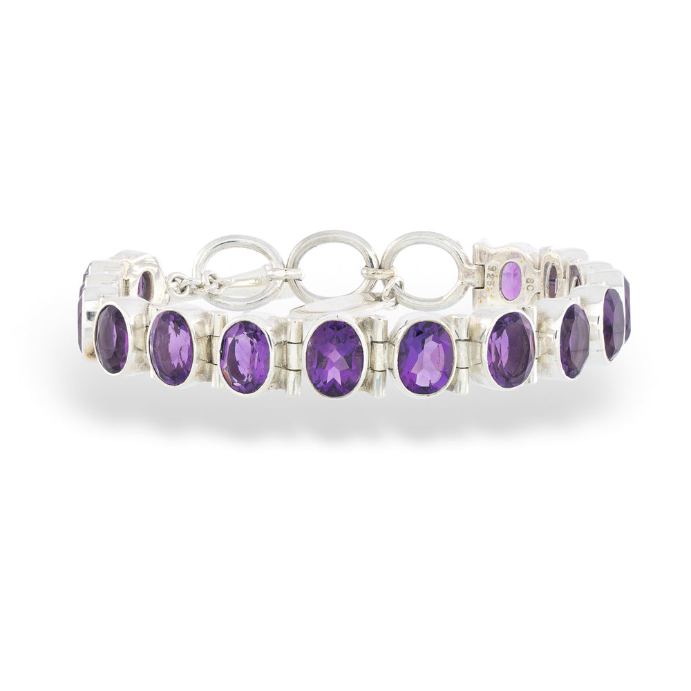 Silver bracelet with purple gemstones on a white background Oval-Cut Amethyst Bracelet by Acleoni
