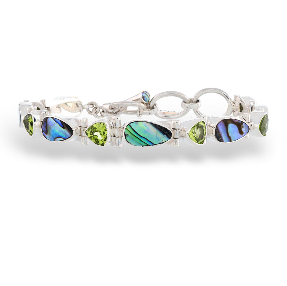 Silver bracelet with green and blue gemstones on a white background Abalone and Peridot Bracelet by Acleoni 