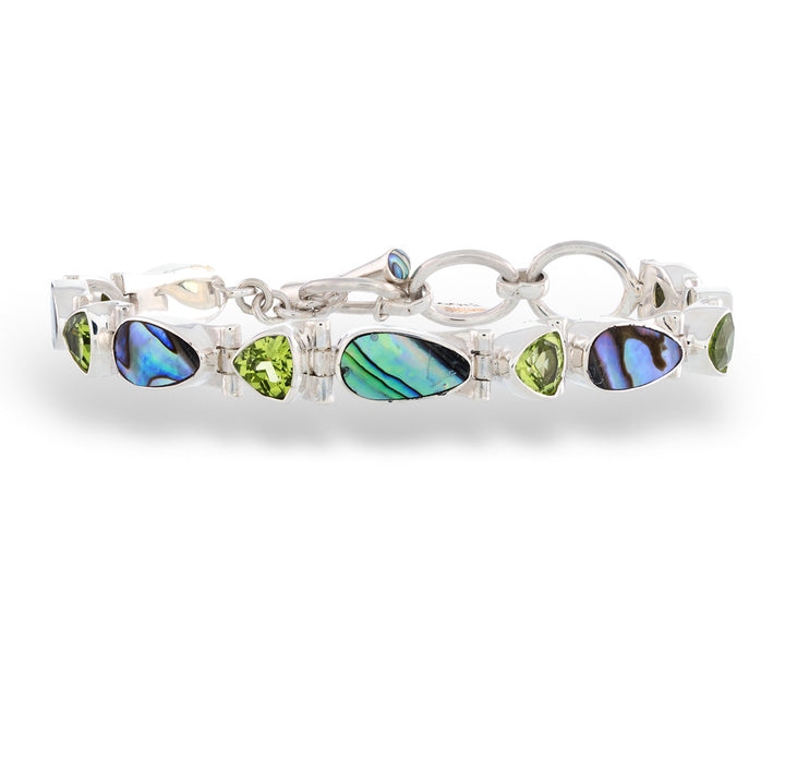 Silver bracelet with green and blue gemstones on a white background Abalone and Peridot Bracelet by Acleoni 