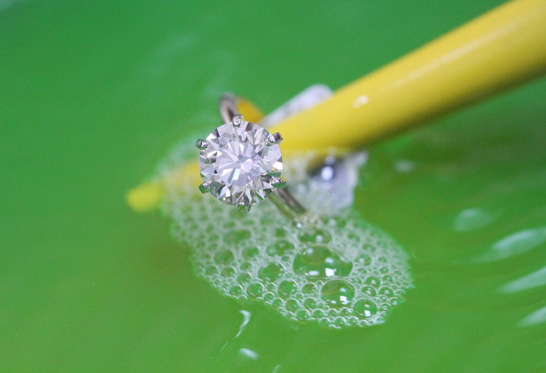 diamond engagement ring in soapy water