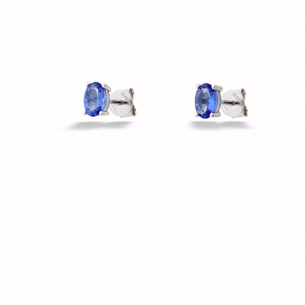 Pair of silver earrings with blue gemstones on a white background Oval Tanzanite Stud Earrings