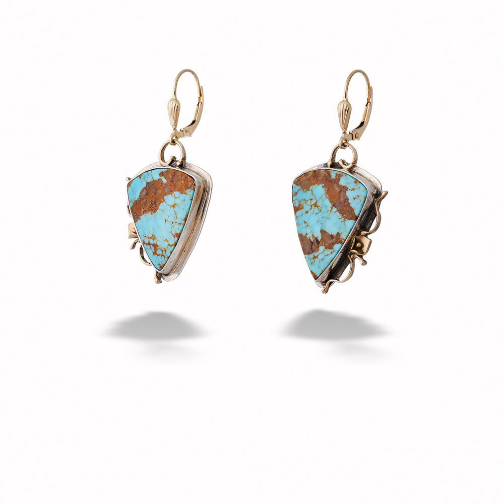 Turquoise stone earrings with gold accents on a white background Triangular Turquoise Earrings with Peace Lily Accents 
