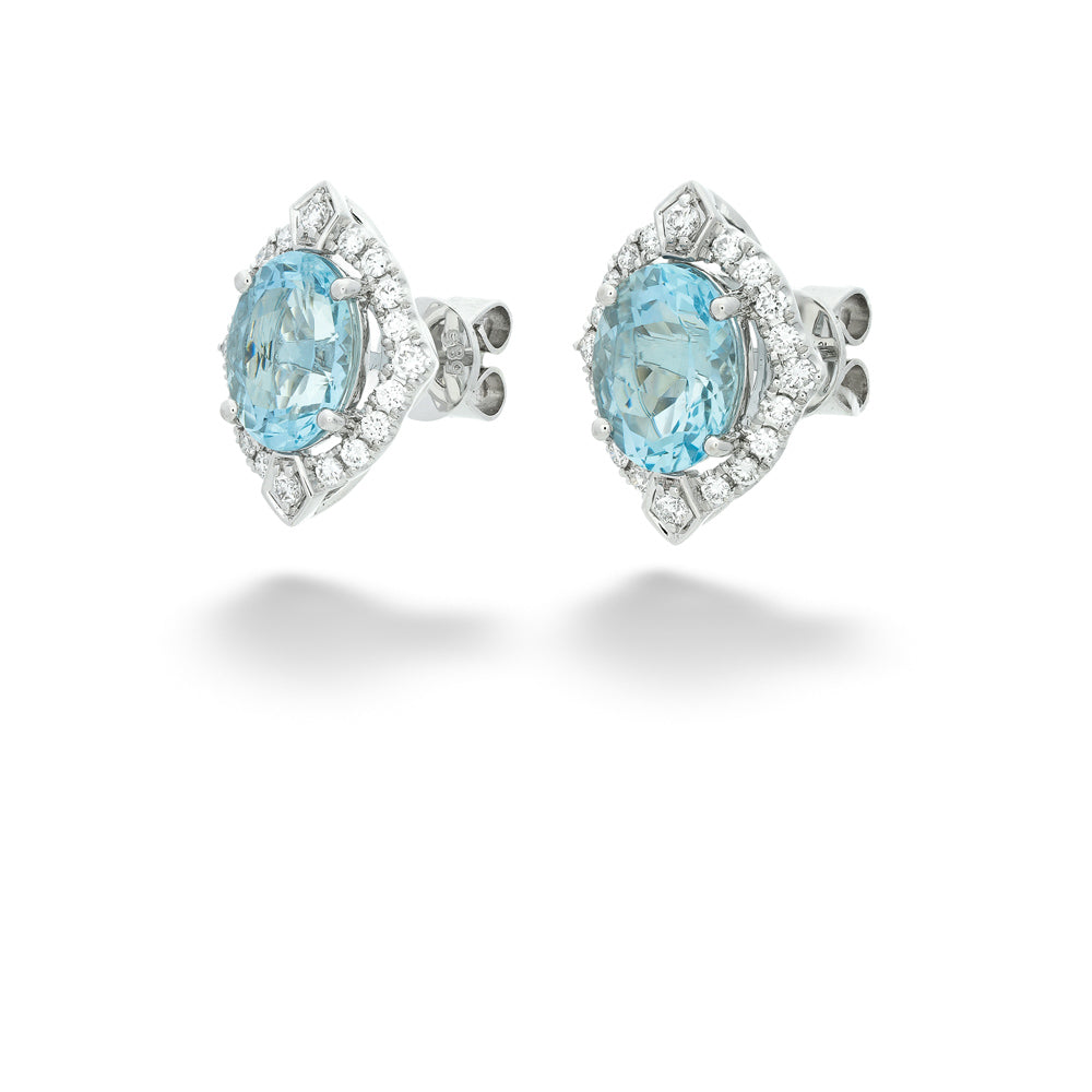 Pair of earrings with blue gemstones and silver settings on a white background Aquamarine and Diamond Stud Earrings 