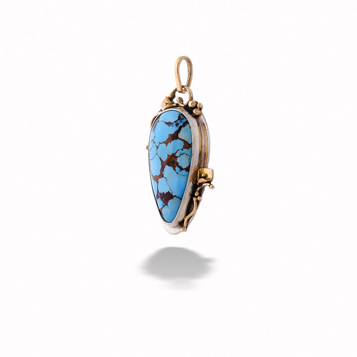 Turquoise pendant with gold setting on a white background Turquoise Pendant with Gold Peace Lilies