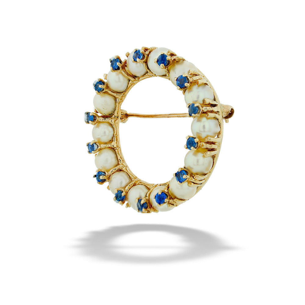 Gold brooch with pearls and blue stones on a white background Pearl and Sapphire Circle Brooch